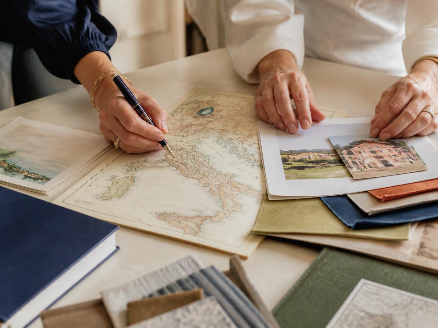 Hands creating a tailor-made Italian journey around a map and local materials